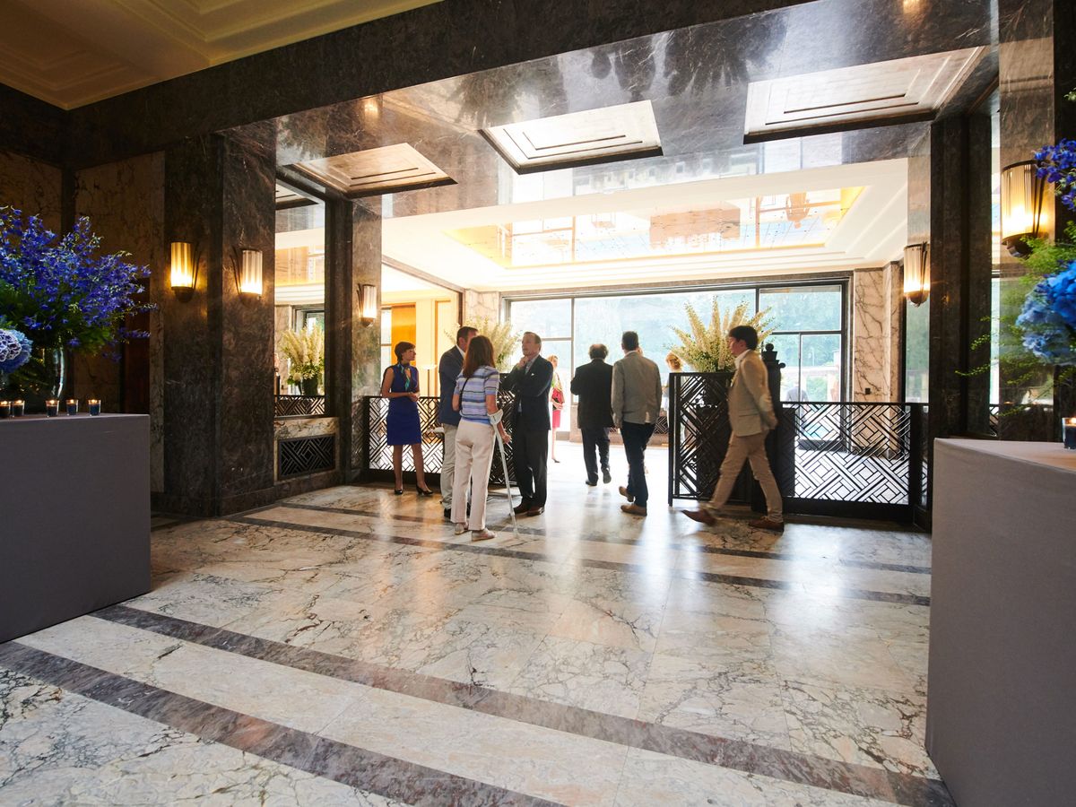Guests in the marble entrance hall of the Villa Empain